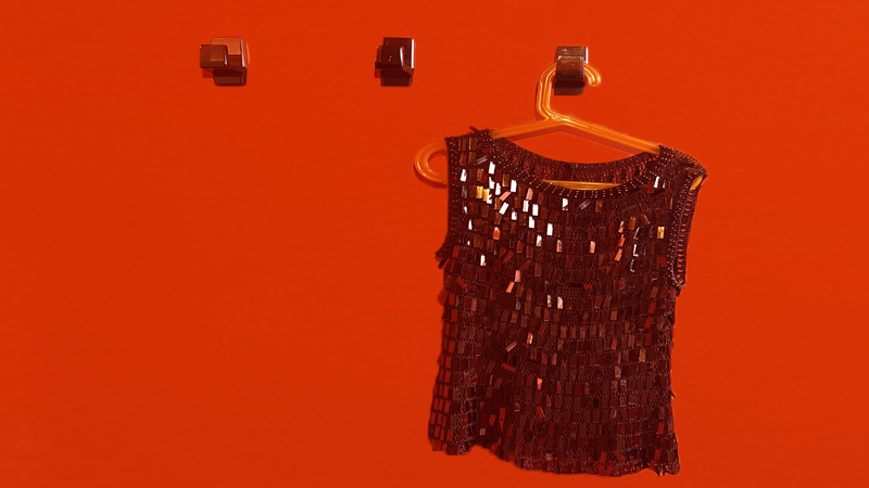 Les couleurs fortes se partagent la salle de bain : l'orange , le brun, le blanc et le noir. Les accessoires ont été minutieusement choisis et récupérés pour recréer une ambiance Pop. Un tabouret TamTam, un tapis  en fil de laine à décor géométrique orange et noir sur fond crème, design seventies, des porte-serviettes, des porte-manteaux et un porte-savon en plexiglas fumé